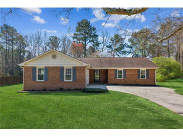 Charming single-story brick home with a well-maintained front lawn and inviting curb appeal at 1604 Quail Sw Run, Conyers, GA 30094