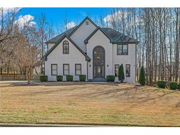 Charming two-story painted brick home with an arched entryway and well-maintained landscaping at 3775 Lake Seminole Dr, Buford, GA 30519