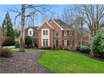 Charming brick two-story home featuring manicured lawn and mature trees at 2883 Observation Nw Pt, Marietta, GA 30064