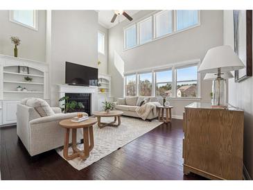 Bright living room with fireplace, high ceilings and many windows offering an abundance of natural light at 4440 Croftshire Pl, Cumming, GA 30040