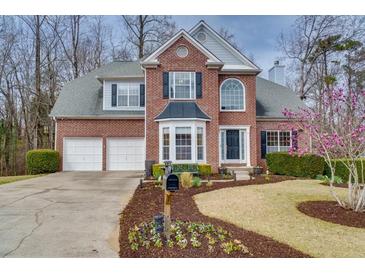 Charming two-story brick home featuring a two-car garage, manicured lawn and garden at 1413 Eastbrooke Way, Marietta, GA 30066