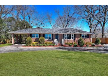 Charming brick ranch home with a well-manicured lawn and mature trees at 4212 Logan Dr, Loganville, GA 30052