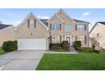 Charming brick two-story home featuring a two-car garage, manicured lawn, and inviting front entrance at 2283 Shady Maple Ln, Loganville, GA 30052