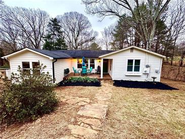 Charming single story home with inviting front porch, stone walkway, and attractive landscaping at 2184 E Cherokee Dr, Woodstock, GA 30188