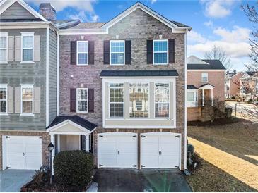 Charming two-story brick townhouse with two-car garage and well-manicured landscaping in a desirable community at 1296 Park Pass Way, Suwanee, GA 30024