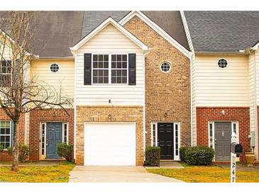 Charming townhome featuring brick and siding facade, single car garage and front lawn at 247 Brookview Dr, Riverdale, GA 30274