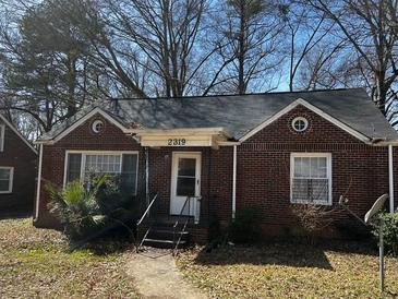 Charming brick home featuring a well-maintained front yard with trees at 2319 Browns Mill Se Rd, Atlanta, GA 30315