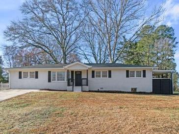 Charming single-story home with a white brick exterior and manicured front yard at 4013 Oglesby Rd, Powder Springs, GA 30127