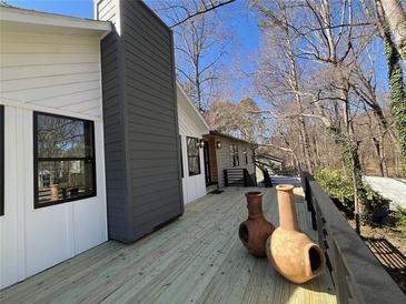 Spacious outdoor deck with decorative pottery, dark metal railings, and a gray and white exterior at 137 Creekview Dr, Woodstock, GA 30188