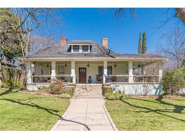 Charming two-story home with a inviting front porch, manicured lawn, and mature trees at 1118 Glenwood Se Ave, Atlanta, GA 30316