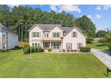 Charming two-story home with a well-manicured lawn and mature landscaping at 1516 Montauk Pt, Conyers, GA 30013