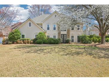 Charming two-story home with stone accents, manicured landscaping, and a lush green lawn at 3500 Fieldstone Xing, Alpharetta, GA 30005