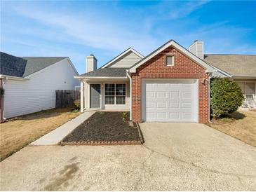 Charming single-story brick home featuring an attached garage and a well-maintained front lawn at 1958 Brittania Cir, Woodstock, GA 30188