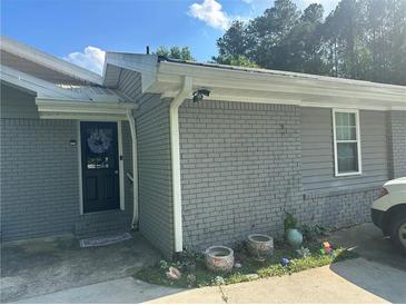 Charming home featuring a black front door adorned with a wreath and gray brick and siding at 3802 Macland Rd, Hiram, GA 30141