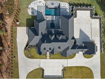 Stunning aerial view of the luxury home with a pool, landscaped grounds, and expansive driveway at 4100 Oak Hill Rd, Douglasville, GA 30135