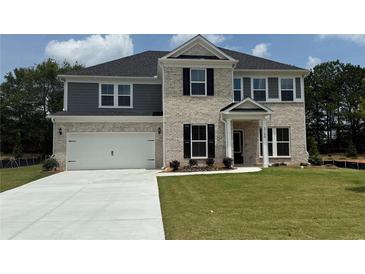Charming two-story home featuring a brick and siding facade, an attached garage, and a well-manicured lawn at 3166 Morris Hills Dr, Dacula, GA 30019