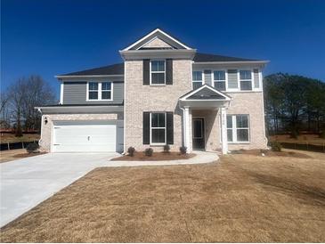 Charming two-story home with a brick facade, well-manicured lawn, and attached two-car garage at 3166 Morris Hills Dr, Dacula, GA 30019
