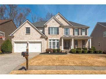 Charming two-story brick home with a well-manicured lawn and attached two-car garage at 4240 Agard St, Cumming, GA 30040