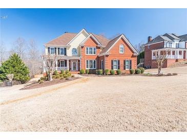 Stunning two-story brick home with manicured lawn and inviting front porch perfect for relaxing at 408 Hickory Fairway Ct, Woodstock, GA 30188