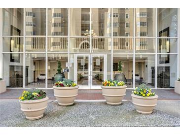 Welcoming building entrance with glass facade, flower planters, and meticulous landscaping at 2479 Peachtree Ne Rd # 508, Atlanta, GA 30305