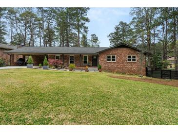 Charming brick ranch home with a well-manicured lawn and covered carport at 3504 Palace Ct, Tucker, GA 30084