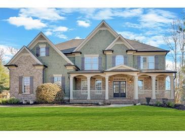 Inviting exterior showcasing a well-manicured lawn, covered porch, and architectural details at 511 Millwood Ct, Canton, GA 30114