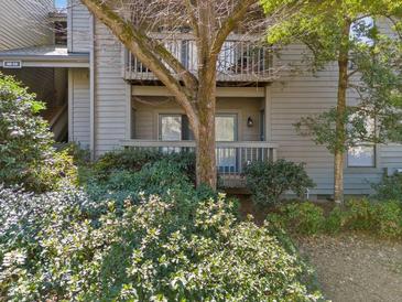 Exterior view of condo building surrounded by green landscaping and mature trees at 213 Tuxworth Cir, Decatur, GA 30033