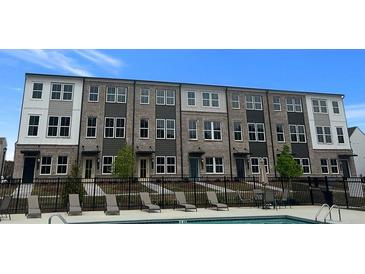 Townhome exteriors overlooking pool area with lounge chairs for residents to enjoy on sunny days at 2664 Brookview Nw Ln, Atlanta, GA 30318