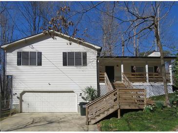 Charming home boasts white siding, black shutters, an attached garage, and a welcoming wooden staircase leading to the front door at 86 Kelly Ct, Dallas, GA 30157