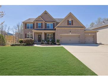 Beautiful two-story brick home with a well-manicured lawn and three-car garage at 194 Lakestone Parkway, Woodstock, GA 30188