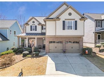 Charming two-story home with a well-maintained lawn, a two-car garage, and a welcoming front porch at 441 Highlands Loop, Woodstock, GA 30188