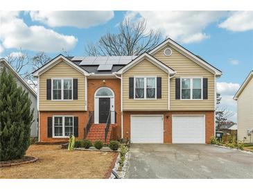 Charming two-story home with a brick and siding exterior and a well-manicured lawn with beautiful brick stairs at 960 Sugar Meadow Dr, Sugar Hill, GA 30518