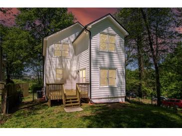 An angle view of this white two story home highlighting the deck with wooden stairs at 2453 Paul Nw Ave, Atlanta, GA 30318