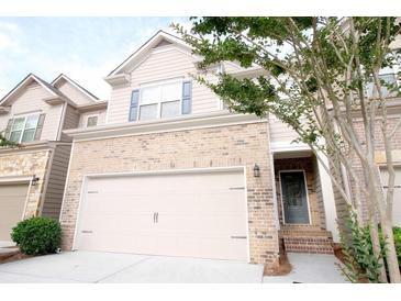 Two-story home featuring a two-car garage, brick accents, and a welcoming entrance with steps at 5975 Vista Brook Dr, Suwanee, GA 30024