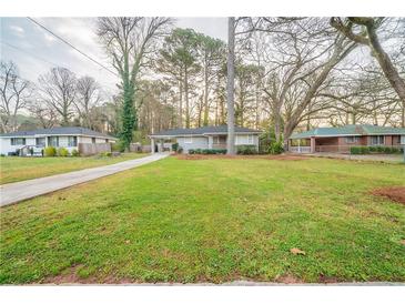 Well-maintained front yard with a charming single-story home and mature trees at 1770 Lynn Ln, Decatur, GA 30032