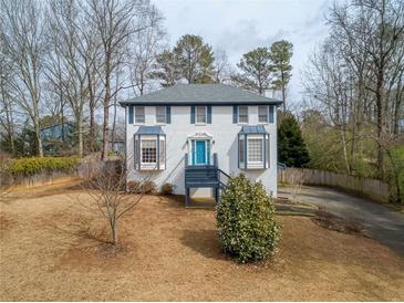 Charming two-story home features a vibrant blue door, bay windows, and a well-maintained front yard at 4646 Breakwater Trl, Marietta, GA 30066