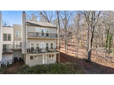 Two-story home featuring dual balconies, gray siding, and a wooded backyard at 10 Colony Ridge Dr, Alpharetta, GA 30022