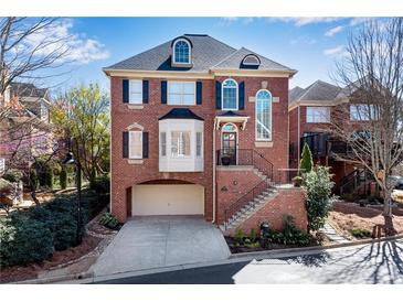 Charming brick home featuring a two-car garage, landscaped front yard, and traditional architectural details at 1029 Fairway Ne Ests, Atlanta, GA 30319