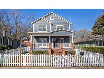 Charming two-story home featuring a welcoming front porch and white picket fence, perfect for curb appeal at 65 Vannoy Se St, Atlanta, GA 30317