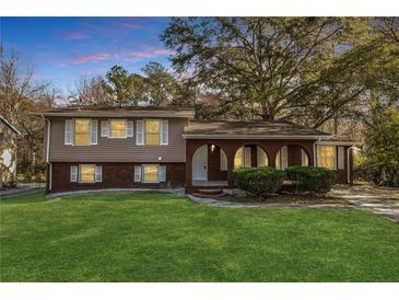 Charming split-level home with brick facade, landscaped front yard, and covered porch at 2670 Foxlair Trl, Atlanta, GA 30349
