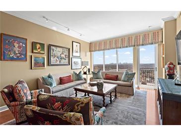 Bright living room with comfortable seating, hardwood floors, and a stunning city view from the balcony at 2950 Mount Wilkinson Se Pkwy # 712, Atlanta, GA 30339