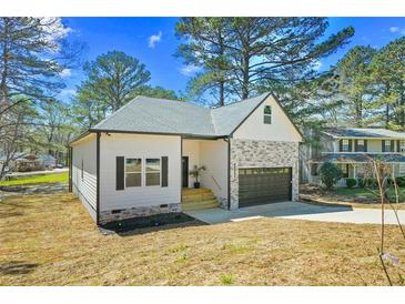 Charming single-Gathering home with stone accents, attached garage, and newly landscaped front yard at 6971 Tan Bark Ct, Riverdale, GA 30296