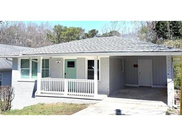 Charming home featuring a freshly painted exterior, covered carport, and light green front door at 2405 Cross Nw St, Atlanta, GA 30318