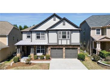 Charming two-story home featuring a two-car garage, stone accents and manicured landscaping at 5470 Beaver Ridge Dr, Cumming, GA 30040