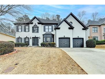 Two-story house with a two-car garage, painted white with black trim and windows on a winter lawn at 901 Blue Sky Rdg, Snellville, GA 30078