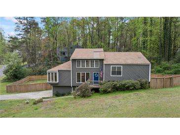 Charming home featuring a front yard, a wooden fence, and a blue door with an American flag at 700 Bayliss Dr, Marietta, GA 30068