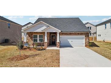 Charming single Gathering home with brick and white accents and an attached two car garage at 6902 Winchester Pl, Fairburn, GA 30213
