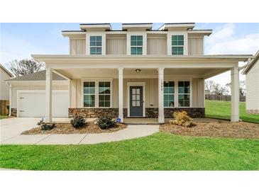 Inviting two-story home with a charming front porch and well-manicured lawn at 1340 Slaton Manor Dr, Conyers, GA 30012