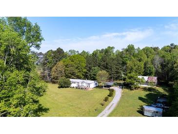 Spacious property featuring a home and outbuildings surrounded by lush greenery and trees at 291 Folsom Glade Rd, Rydal, GA 30171