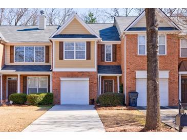 Charming townhome showcasing a brick facade, single-car garage, and manicured landscaping at 927 Abbey Park Way, Lawrenceville, GA 30044